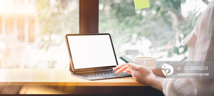 Mockup blank white desktop screen tablet with a woman working in background. White screen tablet for