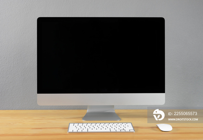 mock up set up of computer desktop system laying on wooden desk with monitor wireless keyboard and m