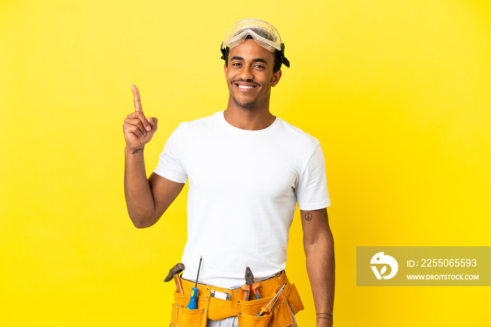 African American electrician man over isolated yellow wall pointing up a great idea