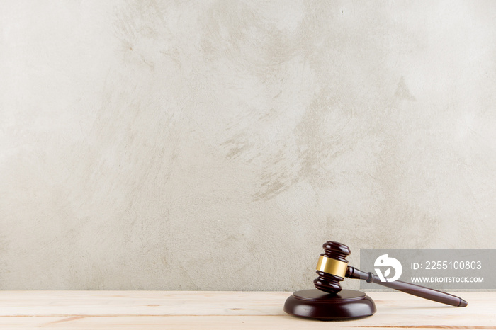 brown gavel with a brass band on a grey background