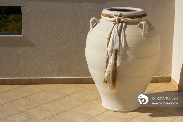 White amphora decorated with fabric. Greek theme.