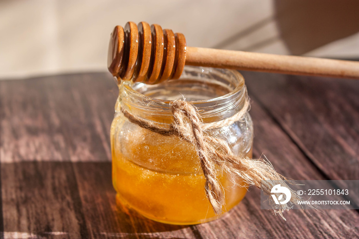 honey in a glass jar on a wooden background