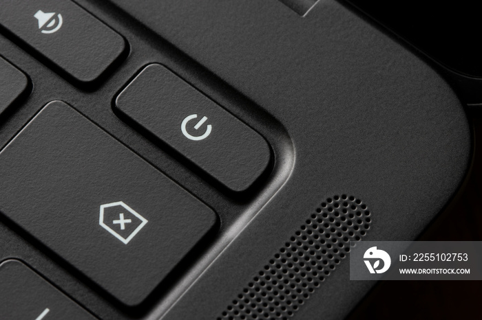 Close up of the power button on a black laptop computer.