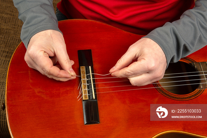 replacement and insertion of nylon strings in a classical guitar. lesson for a musician