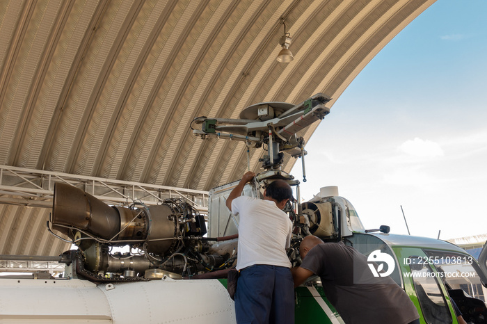 Engineer maintaining a helicopter Engine on the aircraft factory