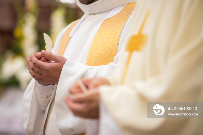 Priest’ hands during a wedding ceremony/nuptial mass (shallow DOF; color toned image)