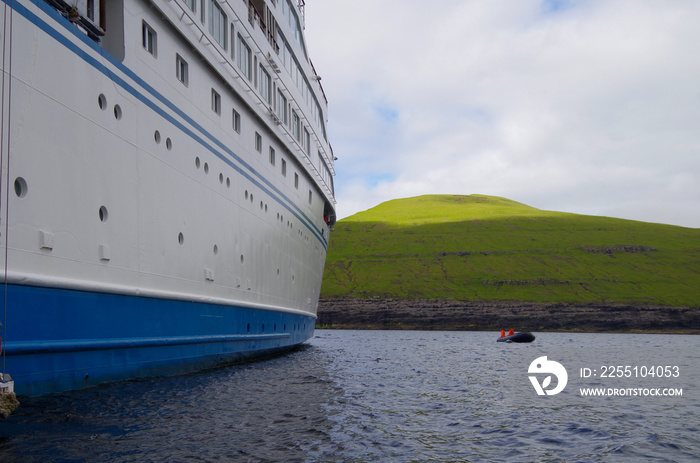 Expedition cruising on luxury cruiseship cruise ship liner to Nordic adventure Polar Circle Faroe Islands with breathtaking nature landscape scenery cliffs coast line