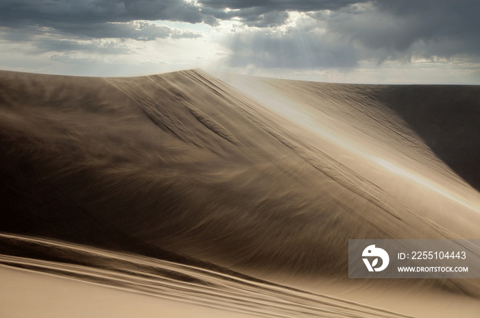 wind blowing the desert sand around on a dune in namibian desert