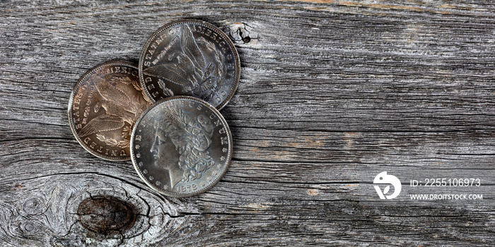 Collection of US Morgan silver dollars with patina finish on weathered wooden boards