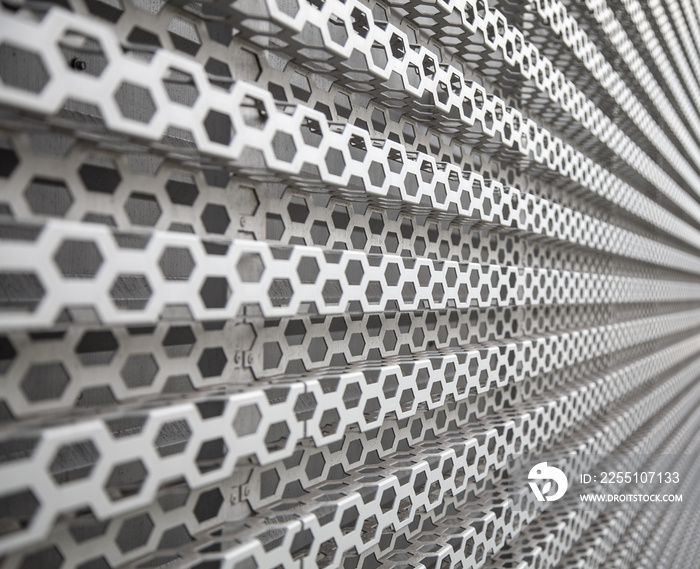 Background of wavy metallic grid with holes. Metal mesh as background. Perforated metal back.