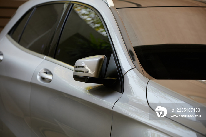 Rear-view mirror or door mirror closed for safety at car park, Side mirror of gray car , black tinted glass