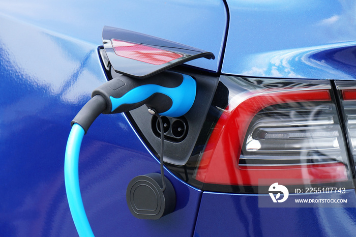 EV or Electric car at charging station with plug-in power supply cable - e-mobility concept