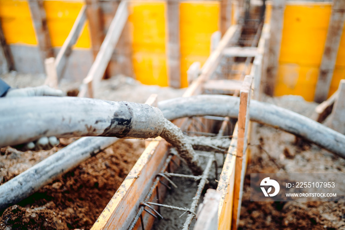 concrete automatic pump working and pouring cement into wooden frames