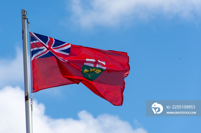 Red Ontario, Canada flag blowing in the wind s on a bright sunny day with blue sky.