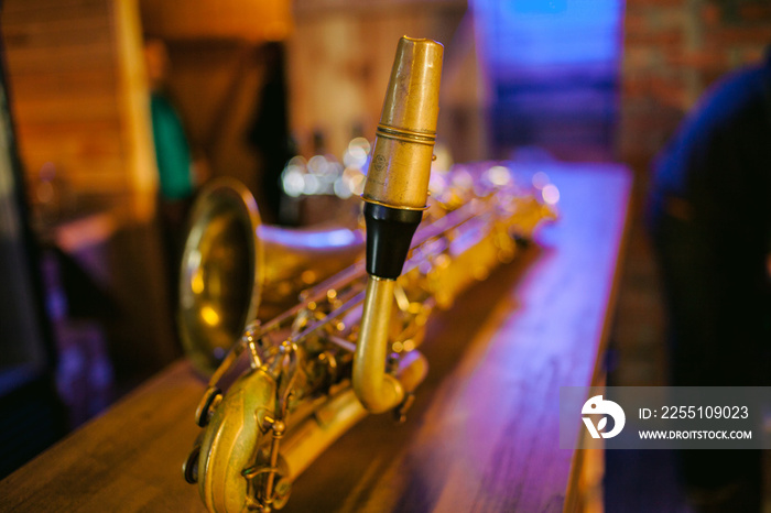 Close up photo of a shiny golden saxophone. Vintage Saxophone. Golden soprano Saxophone. Wind musical instrument. Beautiful golden saxophone on wooden background