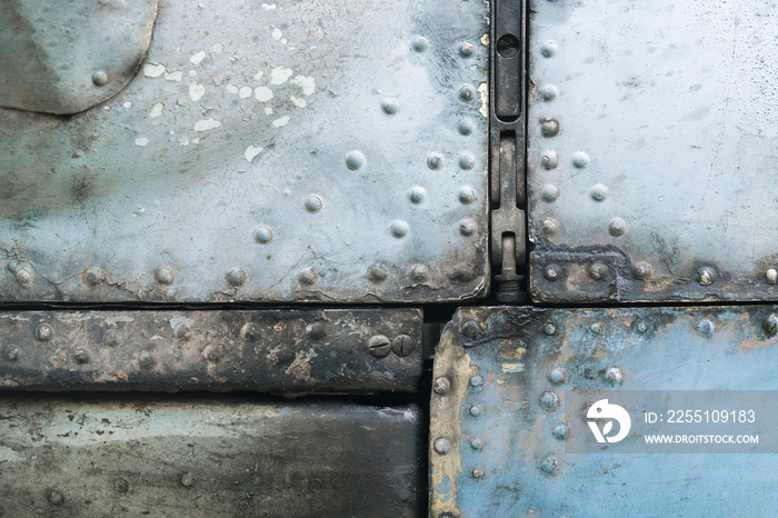 Old blue and silver metal surface of the aircraft fuselage with rivets