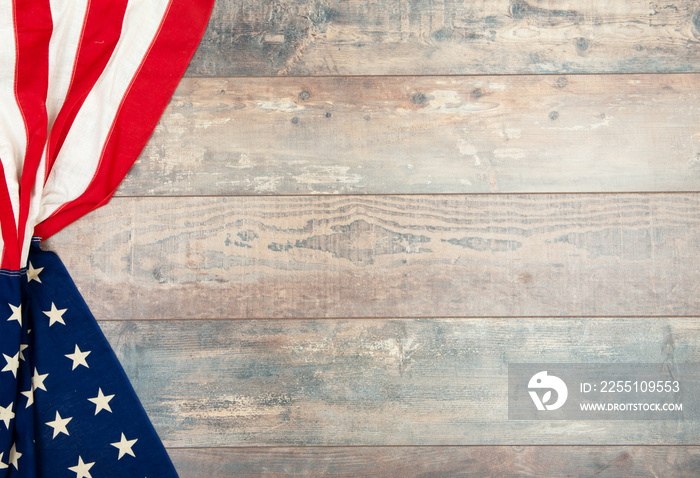 American flag lying on an aged, weathered rustic wooden background.