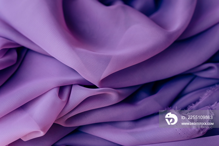 Purple fabric. The texture of the folds on the surface of the purple material. Shop with fabrics.