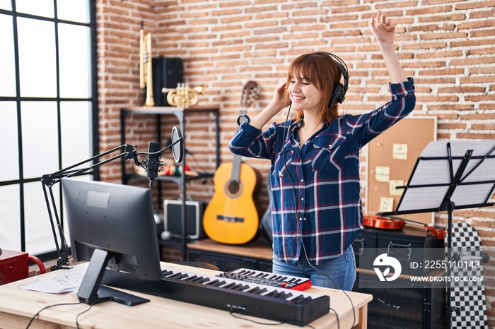 Young woman musician playing piano keyboard at music studio