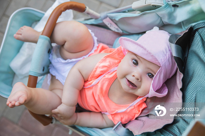 charming newborn baby girl in blue baby carriage