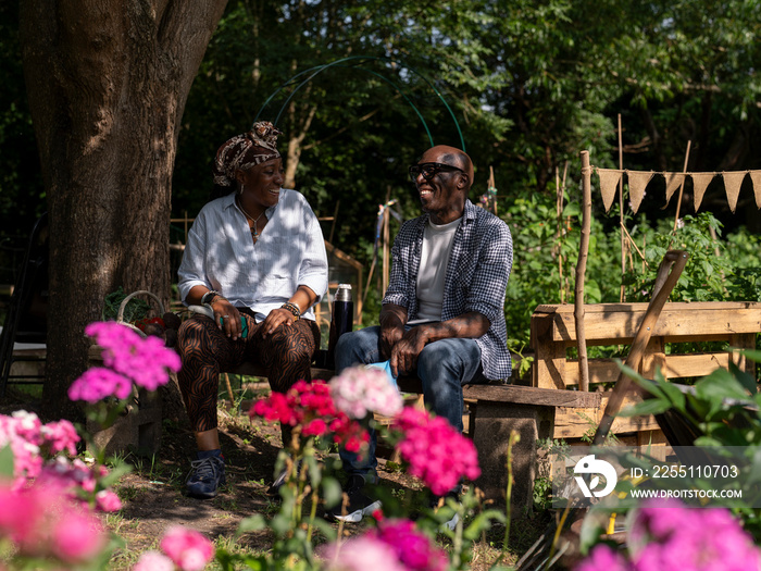 Smiling mature couple relaxing in garden in summer