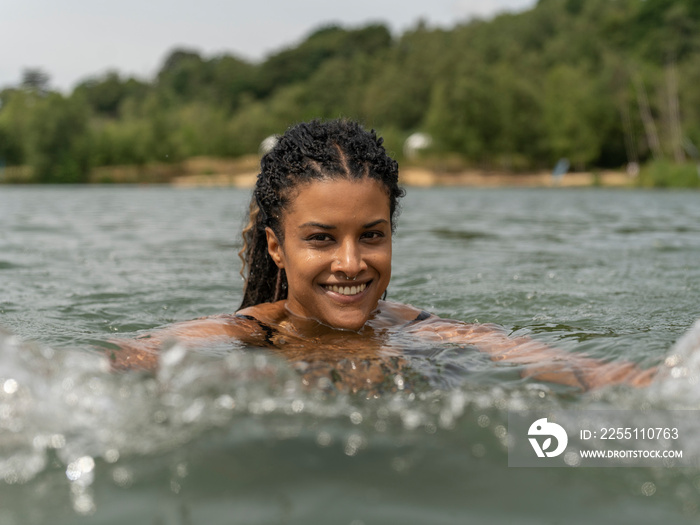 Portrait of smiling woman swimming in lake