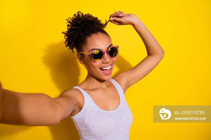 Portrait of cheerful nice girl arm touch hair curl take selfie isolated on yellow color background