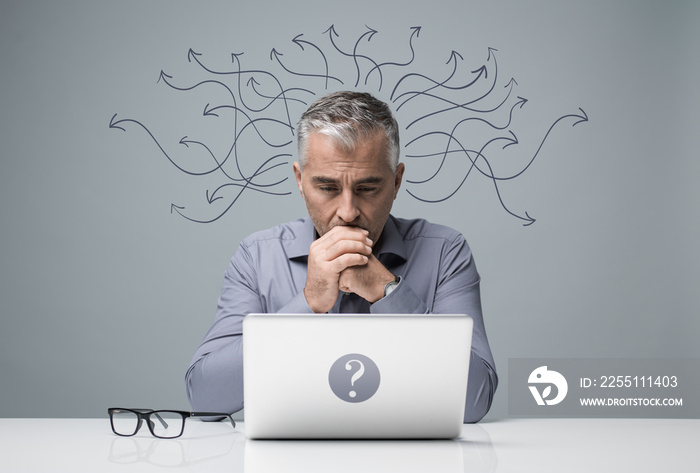 Pensive businessman working with a laptop