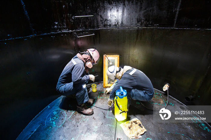 Male two worker inspection scan tank of rust thickness bottom plate