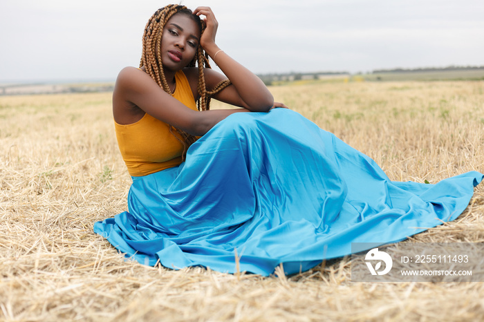 african american young woman having fun outdoors at african american young woman having fun outdoors at sunset. laughing girl on field. beautiful young african american woman with pigtails