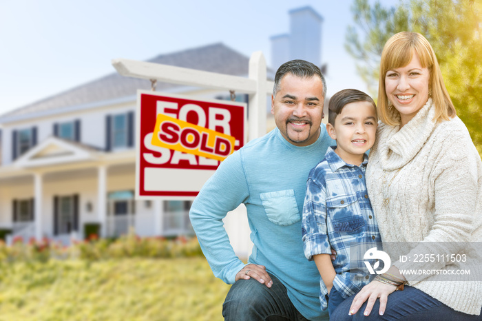 Happy Mixed Race Hispanic and Caucasian Family Portrait In Front of House and Sold For Sale Real Estate Sign.