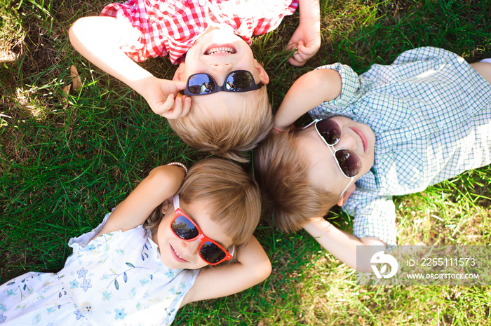 Smiling kids at the garden in sunglasses