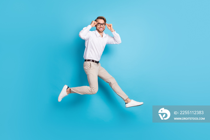 Full length body size view of attractive funny cheerful man jumping running touching specs isolated over bright blue color background