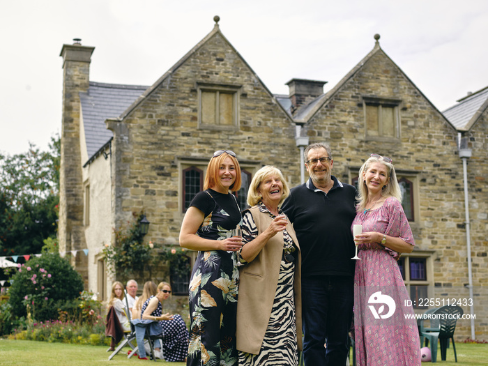 Portrait of smiling family standing in backyard