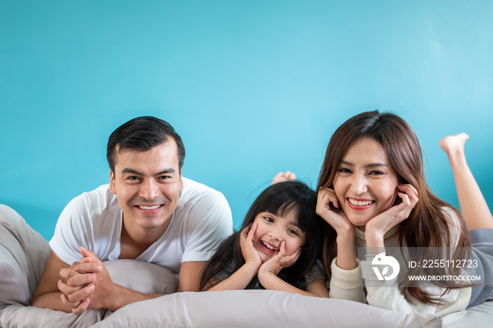 Portrait happy Asian family over blue background