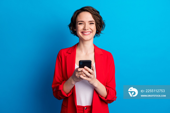 Portrait of attractive cheerful brown-haired businessladylady using gadget like follow isolated on bright blue color background