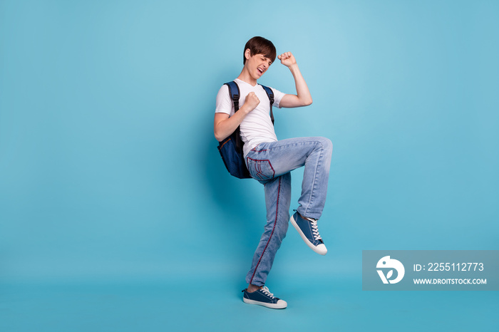 Full length body size photo of dancing rejoicing overjoyed cheerful guy having won olympiad games at math at school while isolated with blue background