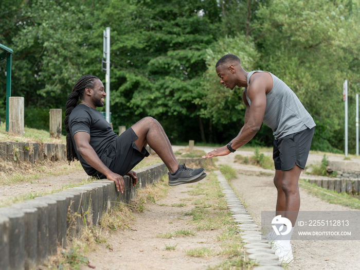 Two men exercising together in park