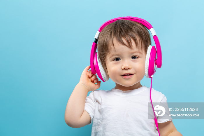 Toddler boy with headphones on a blue background