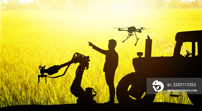 Smart farm agriculture precision technology concept. Silhouette of farmer , automation robot arm machine , uav drone , tractor truck and rice field background. Flare light effect.