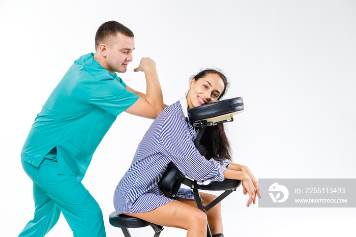 Theme massage and office. Male therapist with blue suit doing back and neck massage for young woman worker, business woman in shirt on massage chair shiatsu