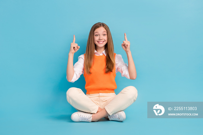 Full length photo of cute pretty lady sitting floor demonstrate empty space shopping sale isolated on blue color background