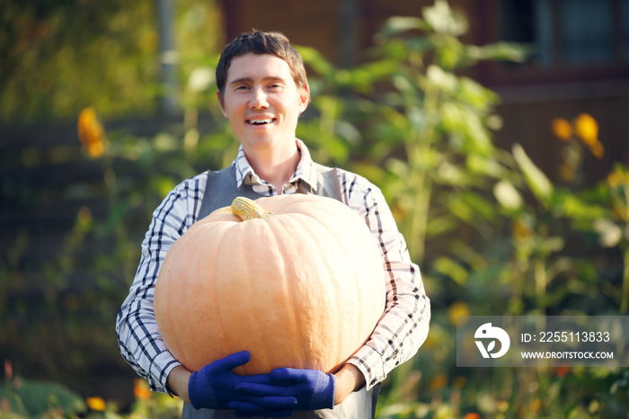 Photo of brunet in blue gloves holding pumpkin