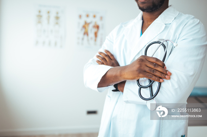 Cropped shot of an unrecognizable doctor holding a stethoscope. Doctor in hospital background with copy space. Healthcare and medical concept. Male african doctor wear medical coat holding stethoscope