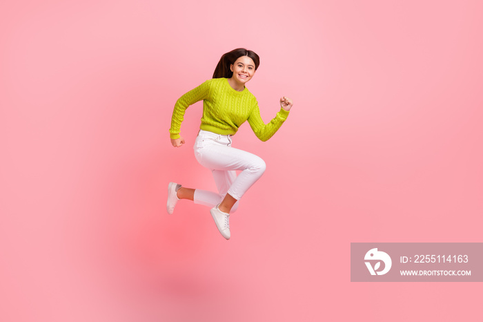 Full size photo of pretty young schoolgirl jump running fast rush have fun dressed stylish green clothes isolated on pink color background