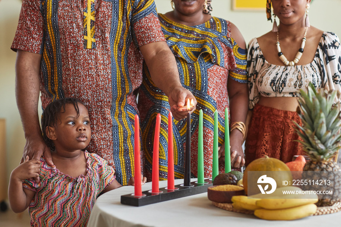 Close-up of African family of four burning seven candles on table together for Kwanzaa holiday