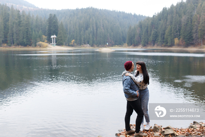 Happy couple on camping trip walk near a lake holding hands