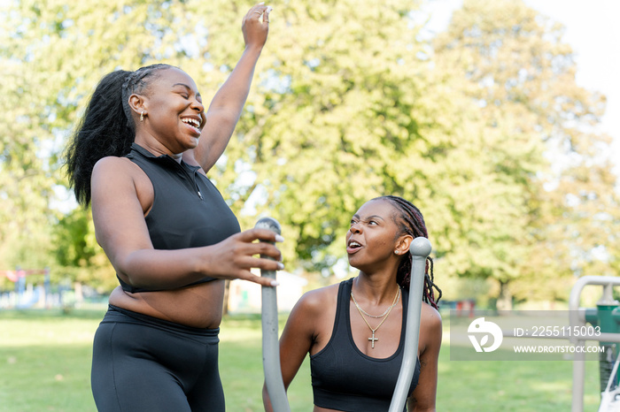 Young female friends exercising in outdoor gym