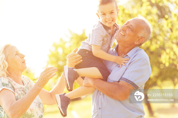 Grandparents with grandson enjoying time together in park.