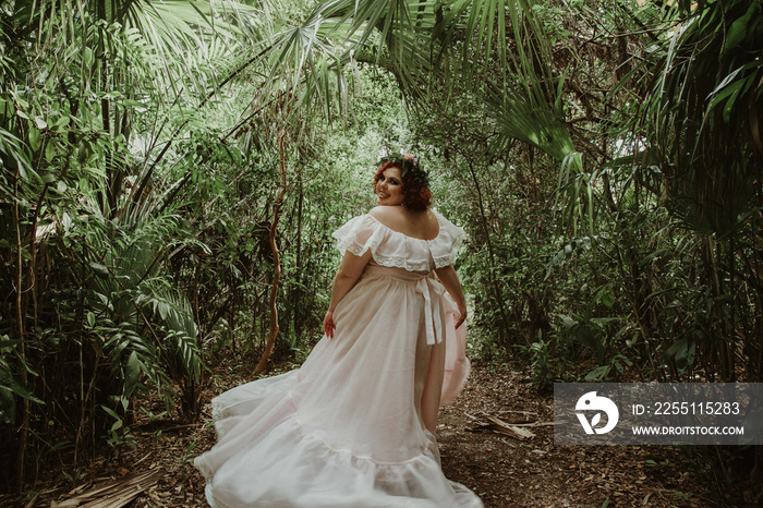 plus size woman looks over shoulder in forest